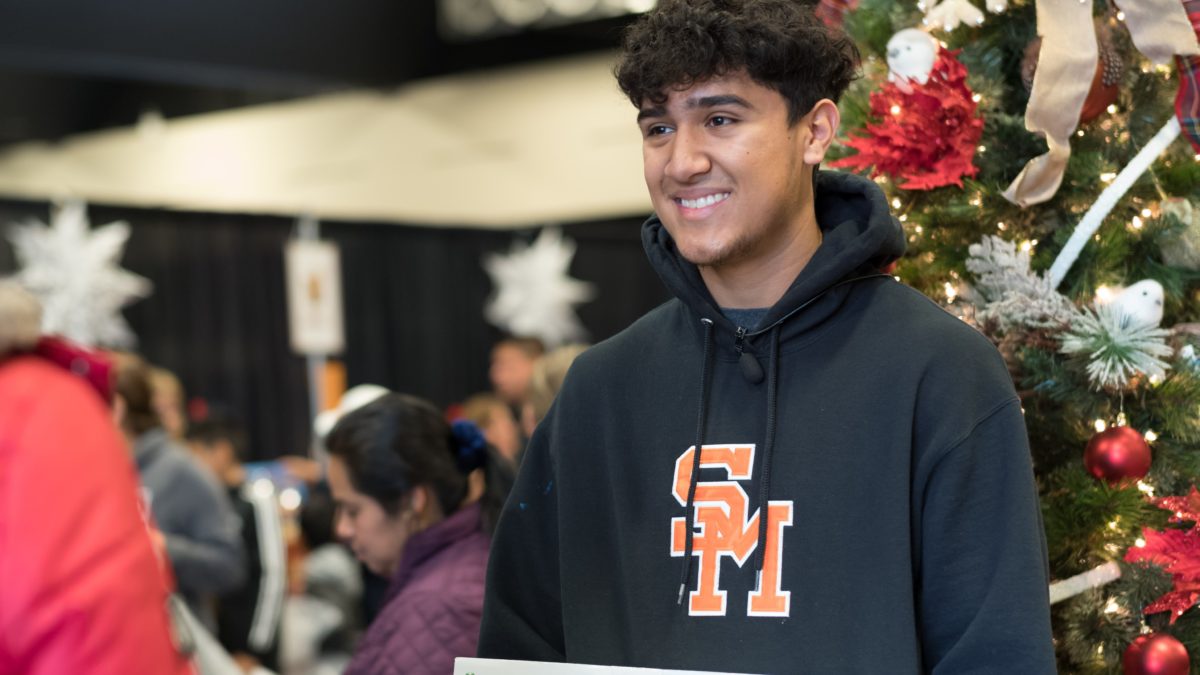 Teen smiling in front of a christmas tree