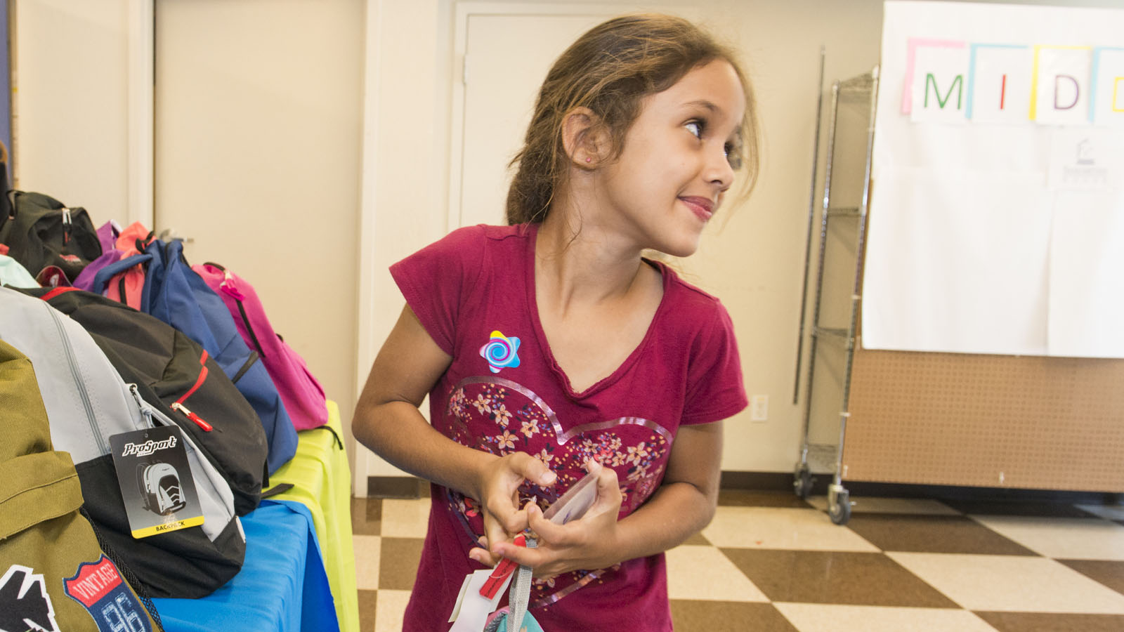 Girl holding backpacks